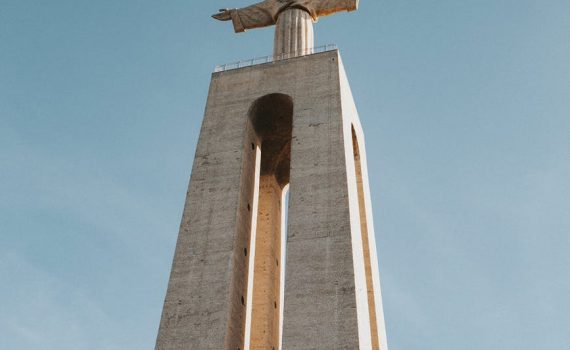 brown concrete cross under blue sky